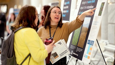 Student presenter discusses research poster